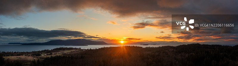 从空中俯瞰圣胡安群岛中的奥卡斯岛背后的壮观日落。图片素材
