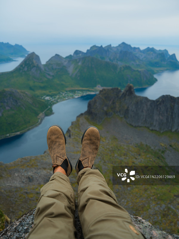 山顶上的男人俯瞰挪威的峡湾图片素材