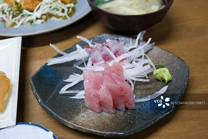 八丈岛的美味刺身，包括幼年黄鳍金枪鱼（Thunnus albacares）和大眼鲹（Seriola dumerili）。在一家客栈享用丰盛的海鲜晚餐。八丈岛，伊豆群岛，东京 - 2025年3月1日。图片素材