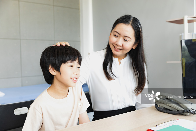 儿童治疗会议，展示了治疗师与小男孩在温馨办公室环境中的亲密互动图片素材