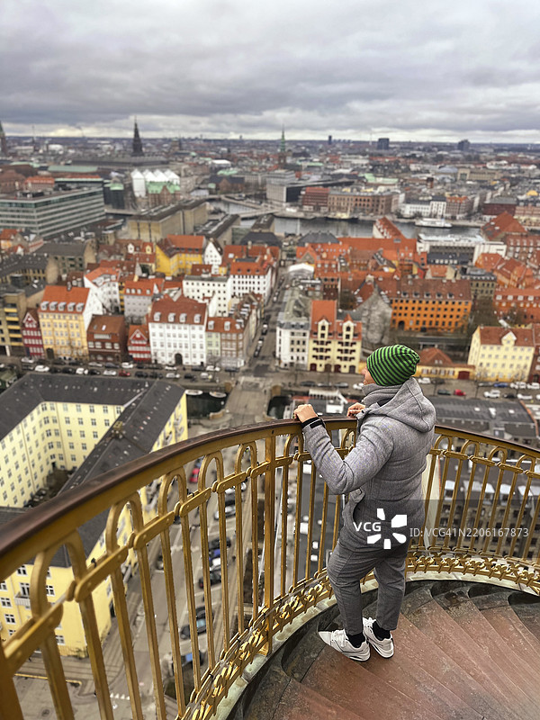 男子在丹麦哥本哈根的螺旋楼梯上欣赏城市风景图片素材