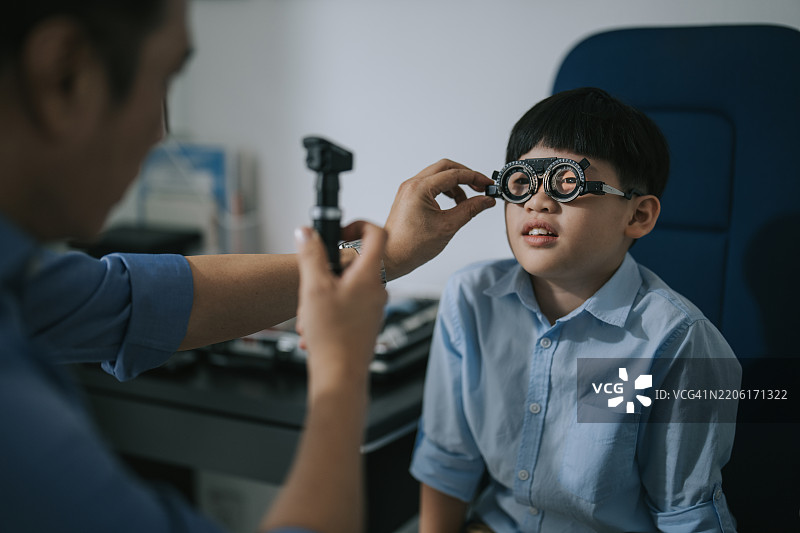 亚洲验光师在诊所为男孩进行视力测试图片素材