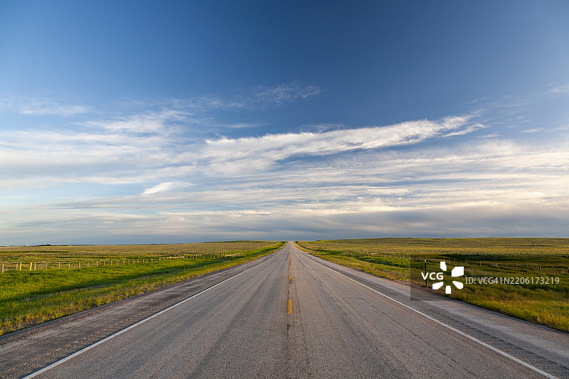 怀俄明州 – 一条空旷的道路延伸穿过广袤的草原景观图片素材