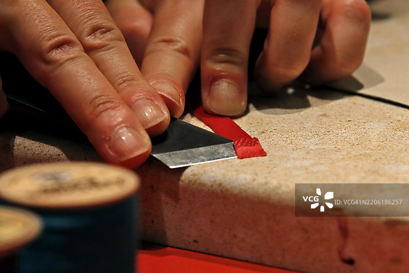 工匠用刀切割皮革图片素材