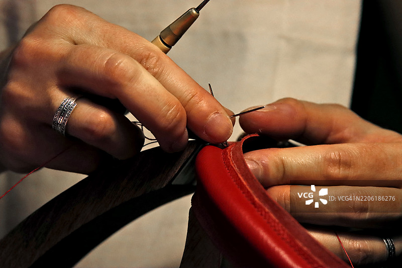 皮革工艺师在工作室的桌子上制作产品图片素材