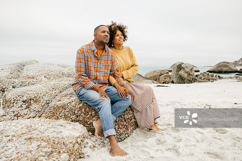 赤脚踩在沙滩上，这对家庭夫妇享受着无忧无虑、宁静的海滩度假。图片素材