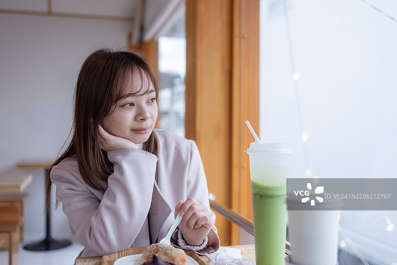 女性游客在咖啡馆放松，欣赏风景的肖像图片素材
