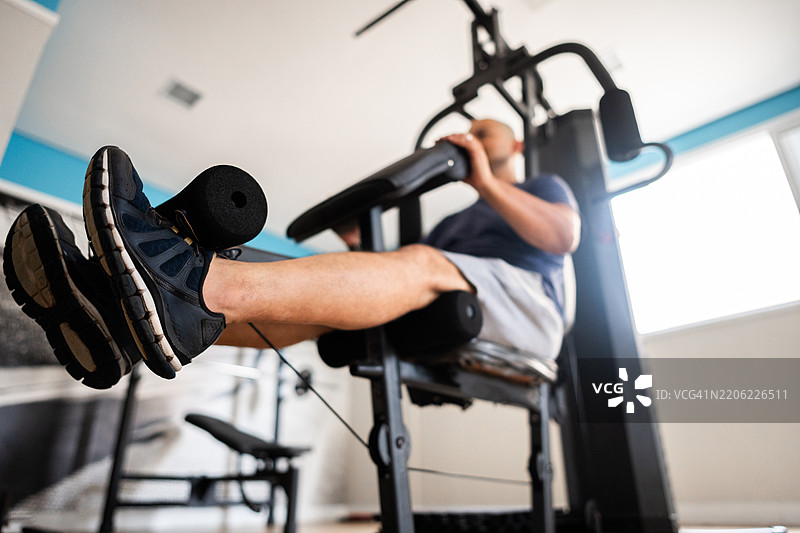 健身房内一名男子在器械上锻炼的特写镜头图片素材