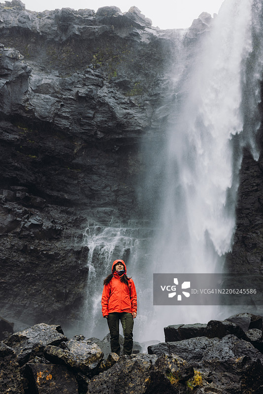 女人在山中欣赏壮丽的瀑布图片素材