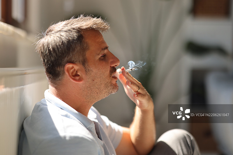 不快乐的中年男人在抽烟图片素材