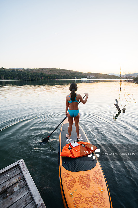 女孩在湖上进行划水探险图片素材