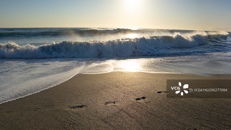 沙滩上波浪拍打时的脚印图片素材