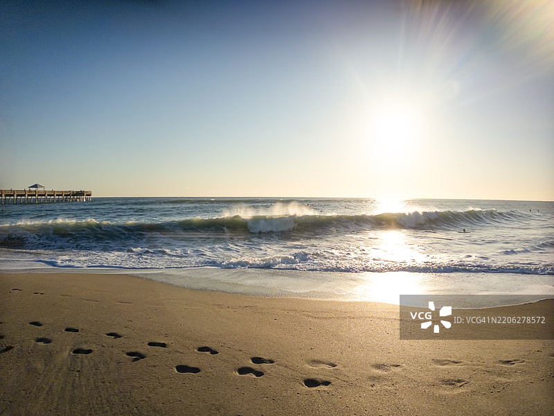 沙滩上的脚印与海浪拍打的声音图片素材