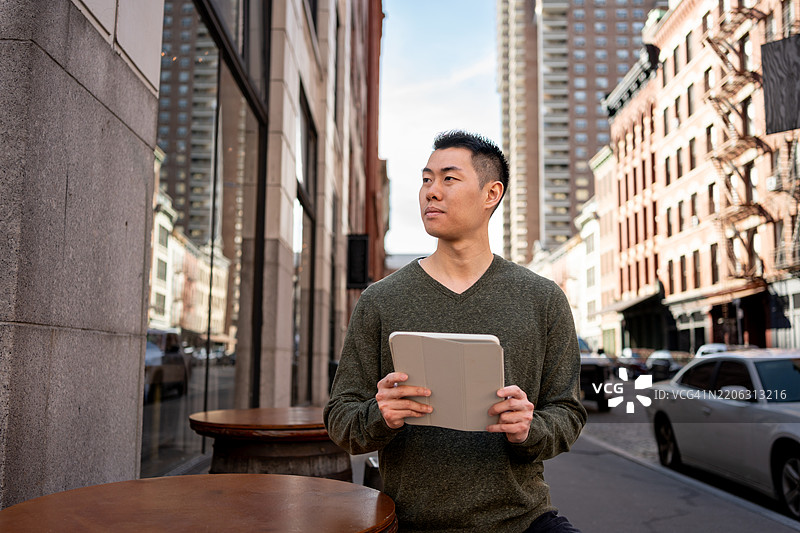 亚洲男子在城市户外手持iPad图片素材