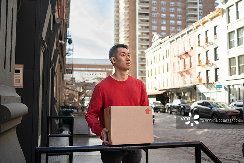 户外一位商人手持纸箱图片素材