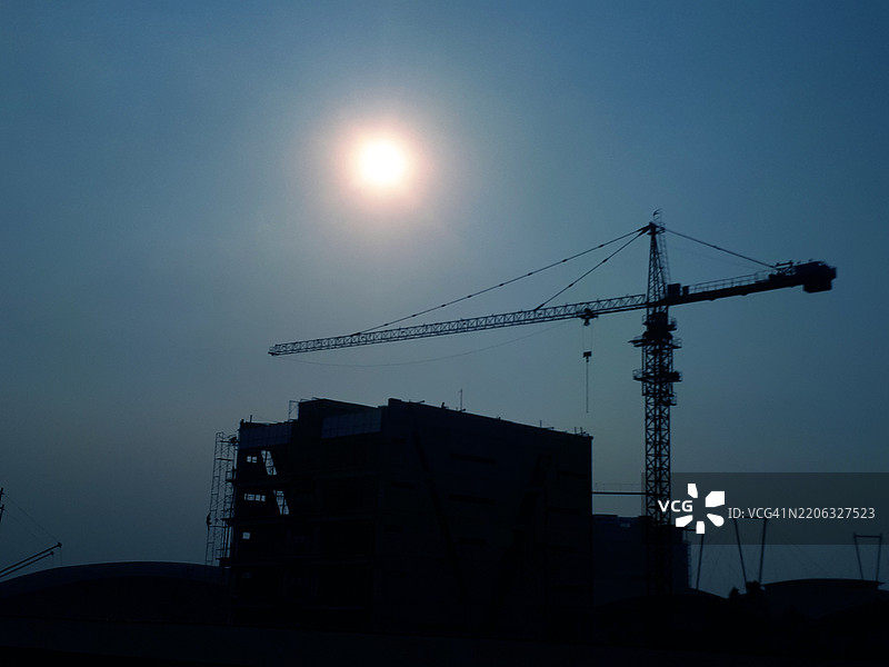 建筑工地的剪影，背景是阳光和蓝天图片素材