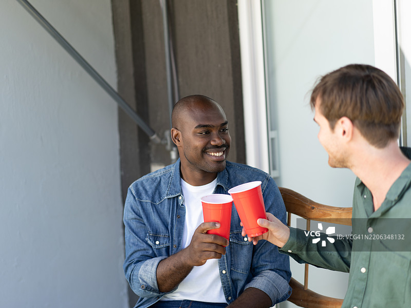 两个年轻人在摊位入口处享受时刻并举杯庆祝图片素材