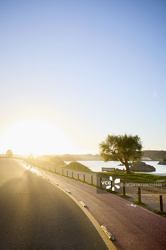 海边日落时的自行车道公路图片素材