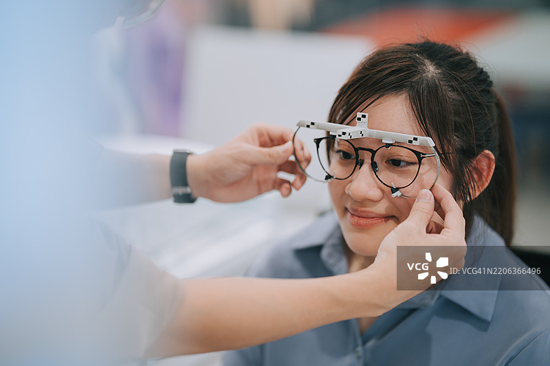 残疾的亚洲华裔女性在眼镜店测量眼镜尺寸和视力图片素材