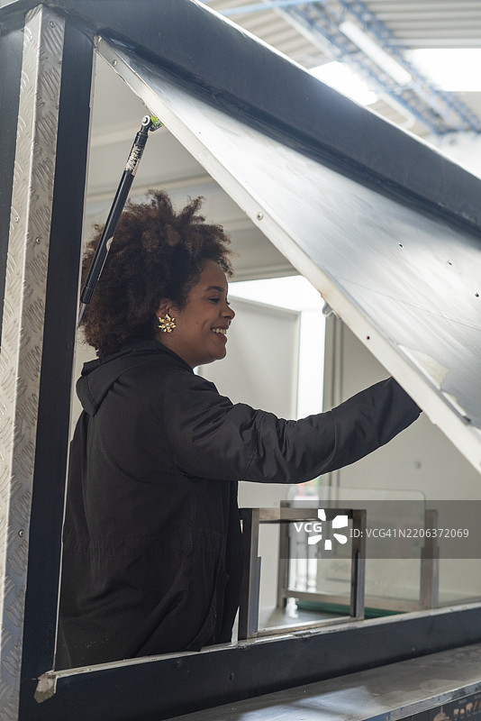 年轻女性查看她的新拖车，准备在这里开设快餐生意。图片素材