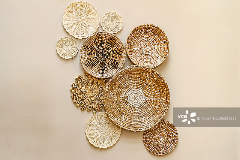 装饰性锅垫悬挂在奶油色背景墙上图片素材