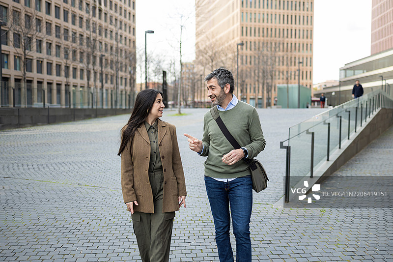 商务人士在现代城市中走动并交谈图片素材