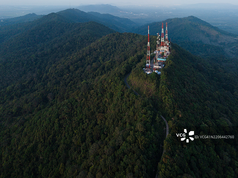 郁郁葱葱的森林山峰上的通信塔，鸟瞰图展示了基础设施与自然的结合。图片素材