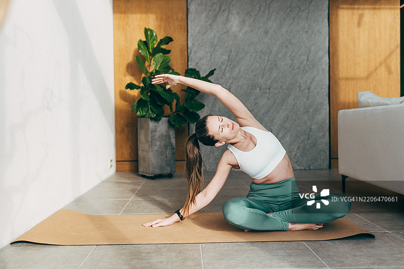 年轻美女在家做瑜伽图片素材
