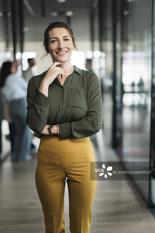 自信的女商人在现代办公室走廊微笑图片素材