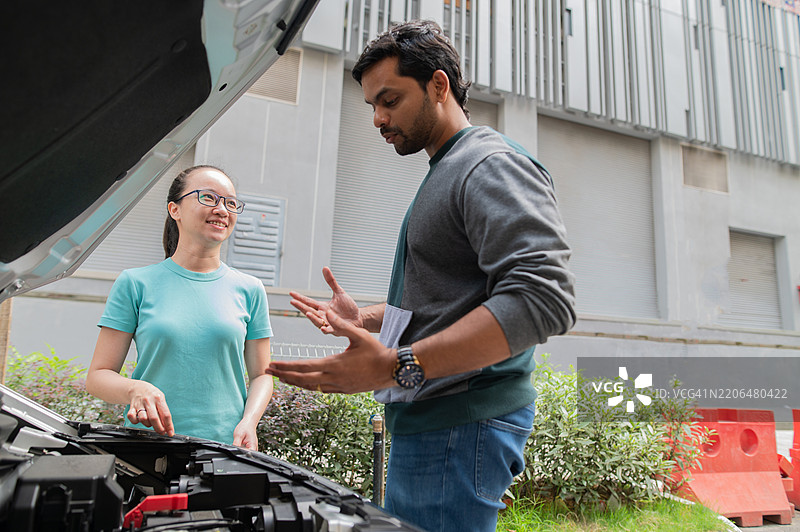 亚洲华裔女性汽车故障，印度男性提供帮助图片素材