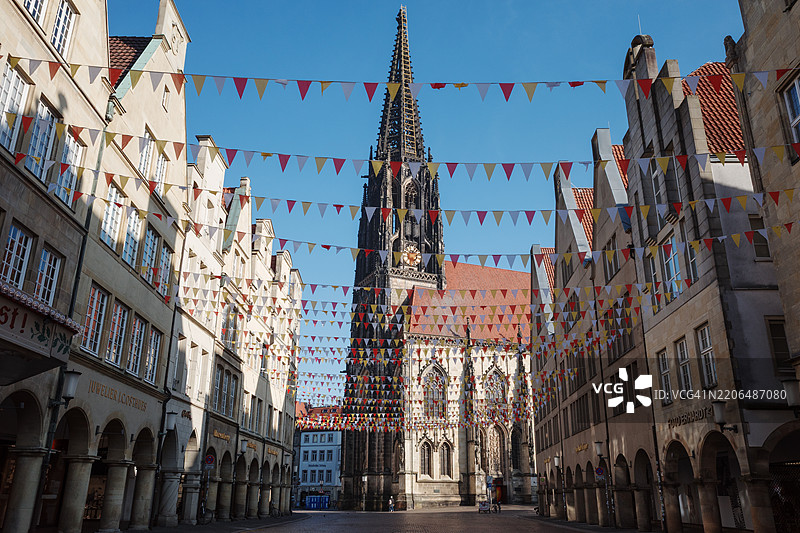 德国明斯特的原则市场外部阳光明媚的景观，背景是圣兰伯特教堂。图片素材
