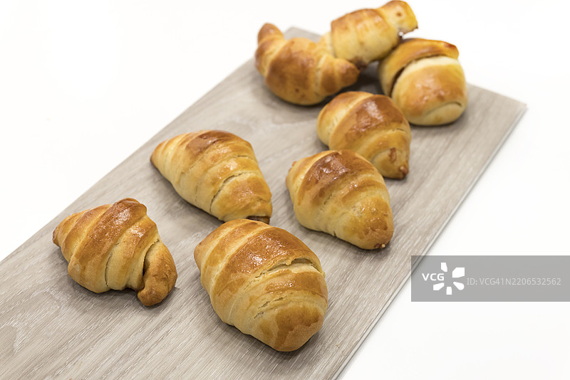 新鲜出炉的可颂面包放在木板上图片素材