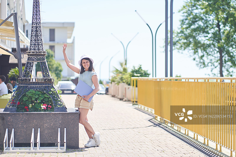 商务旅行到南方国家的概念。戴着帽子的女人与笔记本电脑在一起，显得很开心。图片素材