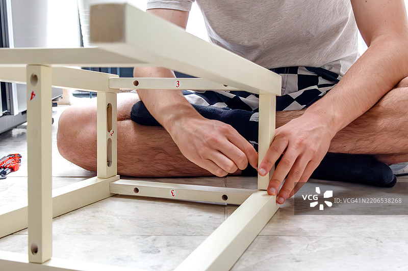 男人在拧木椅的部件图片素材