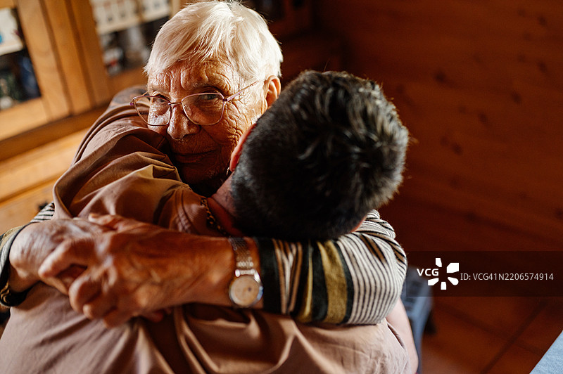 百岁祖母在家中拥抱她的孙子图片素材