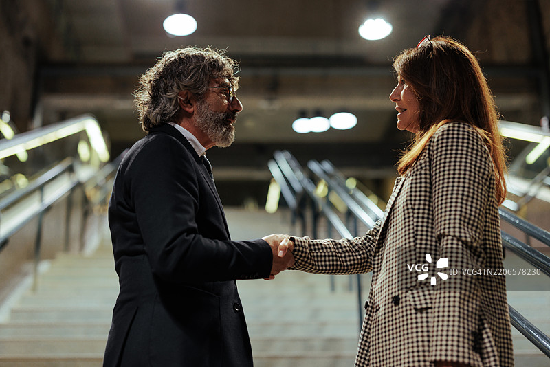 商人在火车站握手交流图片素材