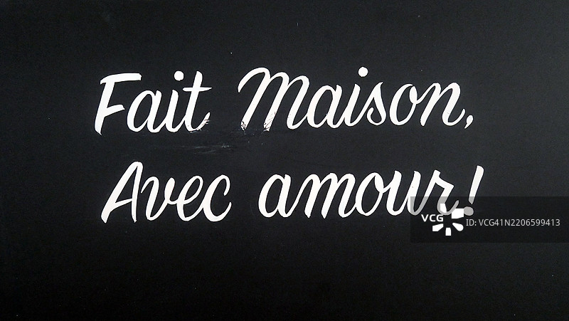 “用爱自制”用法语手写在一家餐厅的外墙上。法国巴黎。自然色彩。阳光照耀。图片素材