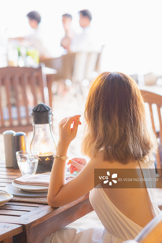 一位年轻的女旅行者在泰国甲米的Railay海滩品尝泰国美食图片素材