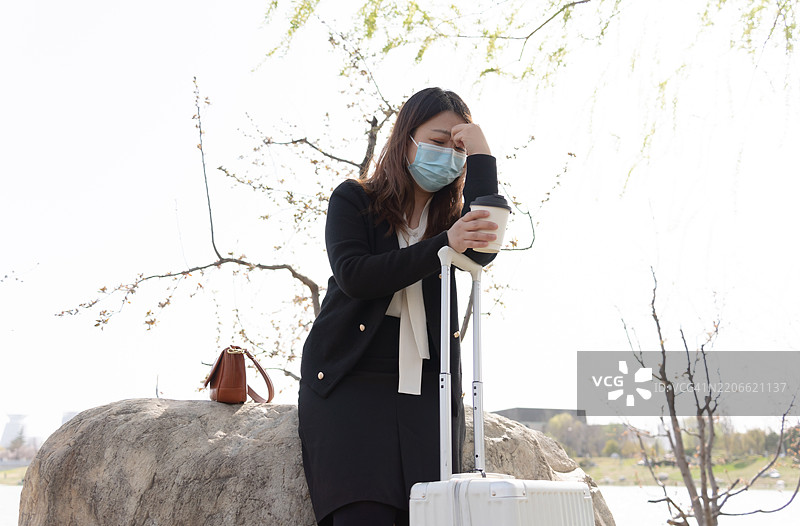 一位亚洲女性在旅行中感到头痛并皱眉。图片素材