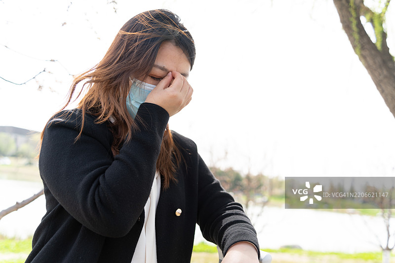 一位亚洲女性在旅行中感到头痛并皱眉。图片素材