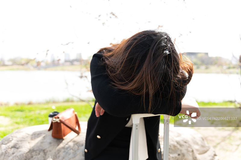 一位亚洲女性在旅行中感到头痛并皱眉。图片素材