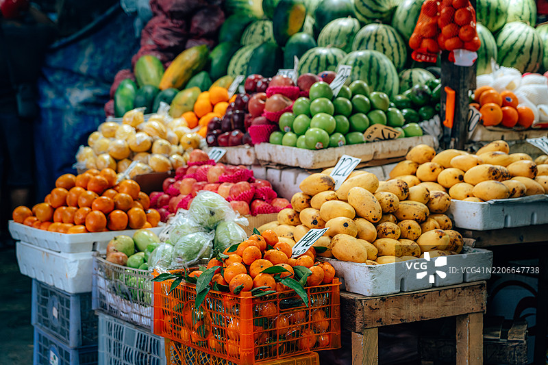 五彩缤纷的水果在热闹的市场摊位上展示图片素材