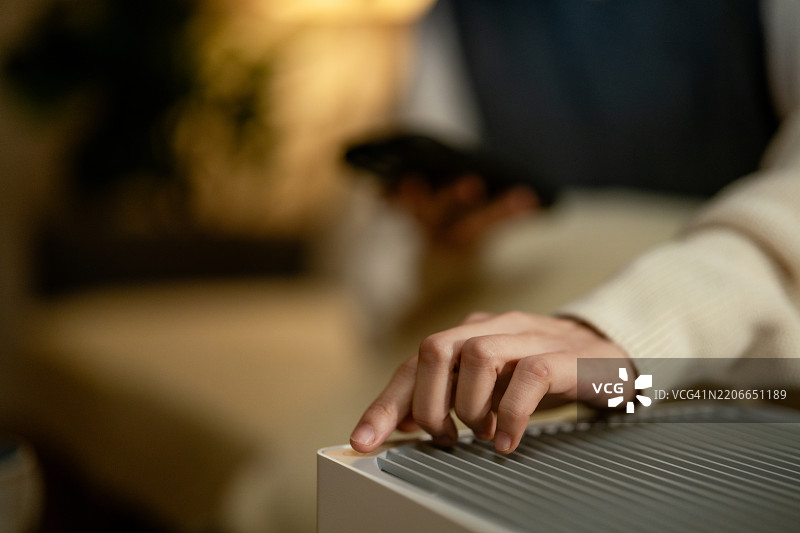 女人在客厅里打开空气净化器图片素材