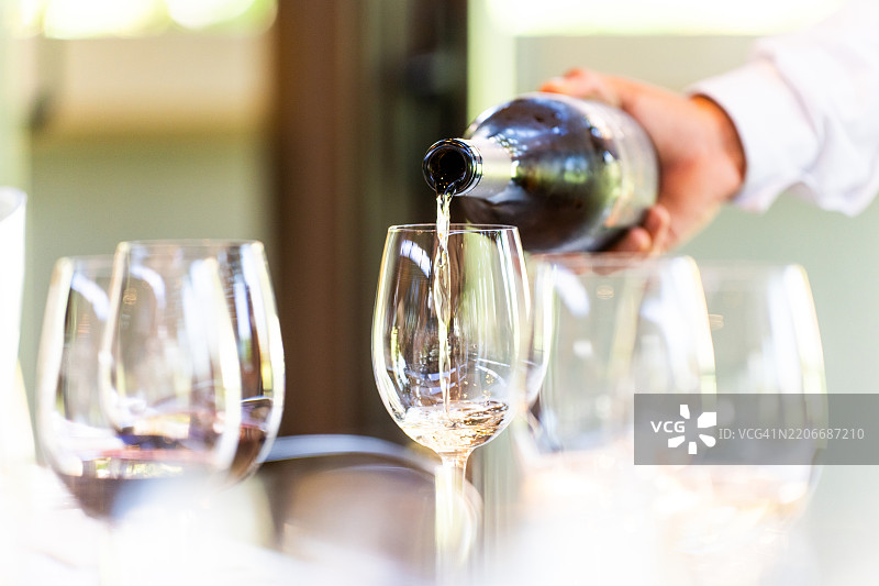 一位服务员端上一杯白葡萄酒图片素材