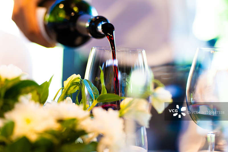 一名服务员在品酒会上倒酒。图片素材