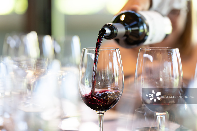 一名服务员在品酒会上倒入一杯赤霞珠葡萄酒图片素材
