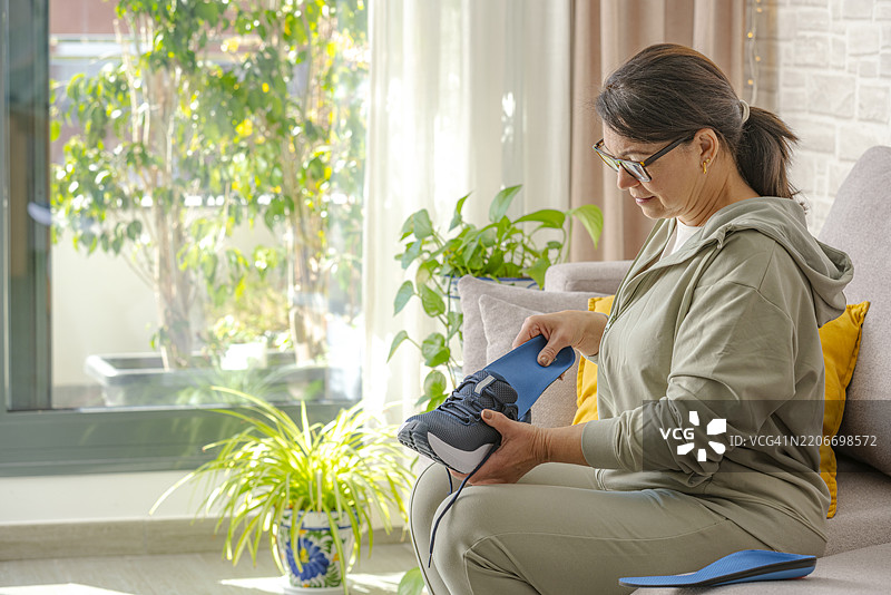 女人在运动鞋中放入鞋垫图片素材