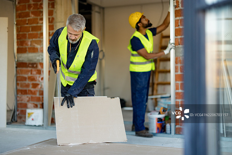 一组建筑工人在室内合作进行建筑翻新项目图片素材