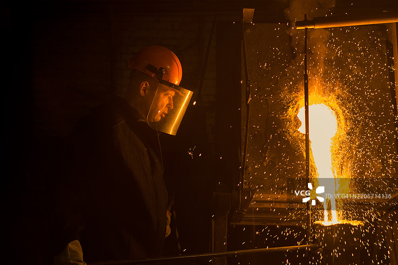 冶炼工人将液态金属倒入铸造模具中图片素材