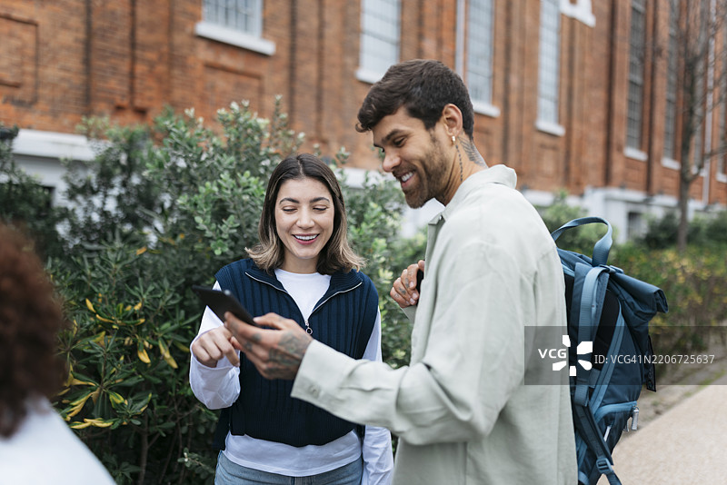 两位年轻人在户外使用智能手机导航图片素材